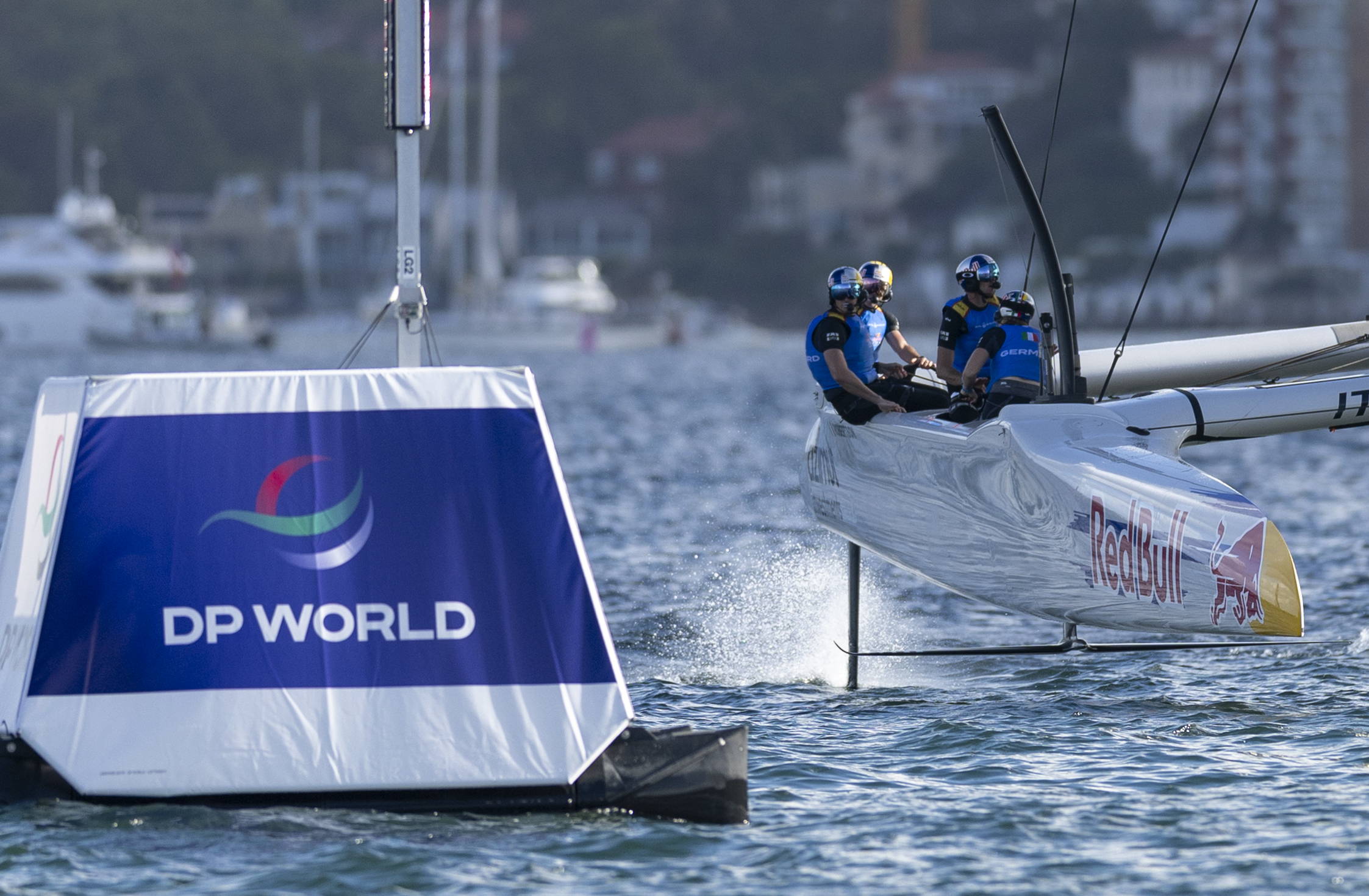 The Red Bull Italy SailGP Team race past a DP World racecourse boundary marker on Race Day 1 of the KPMG Australia Sail Grand Prix in Sydney, Australia. Saturday 28 February 2026. Rolex SailGP Championship Event 3 2026 Season. Photo: Simon Bruty for SailGP. Handout image supplied by SailGP