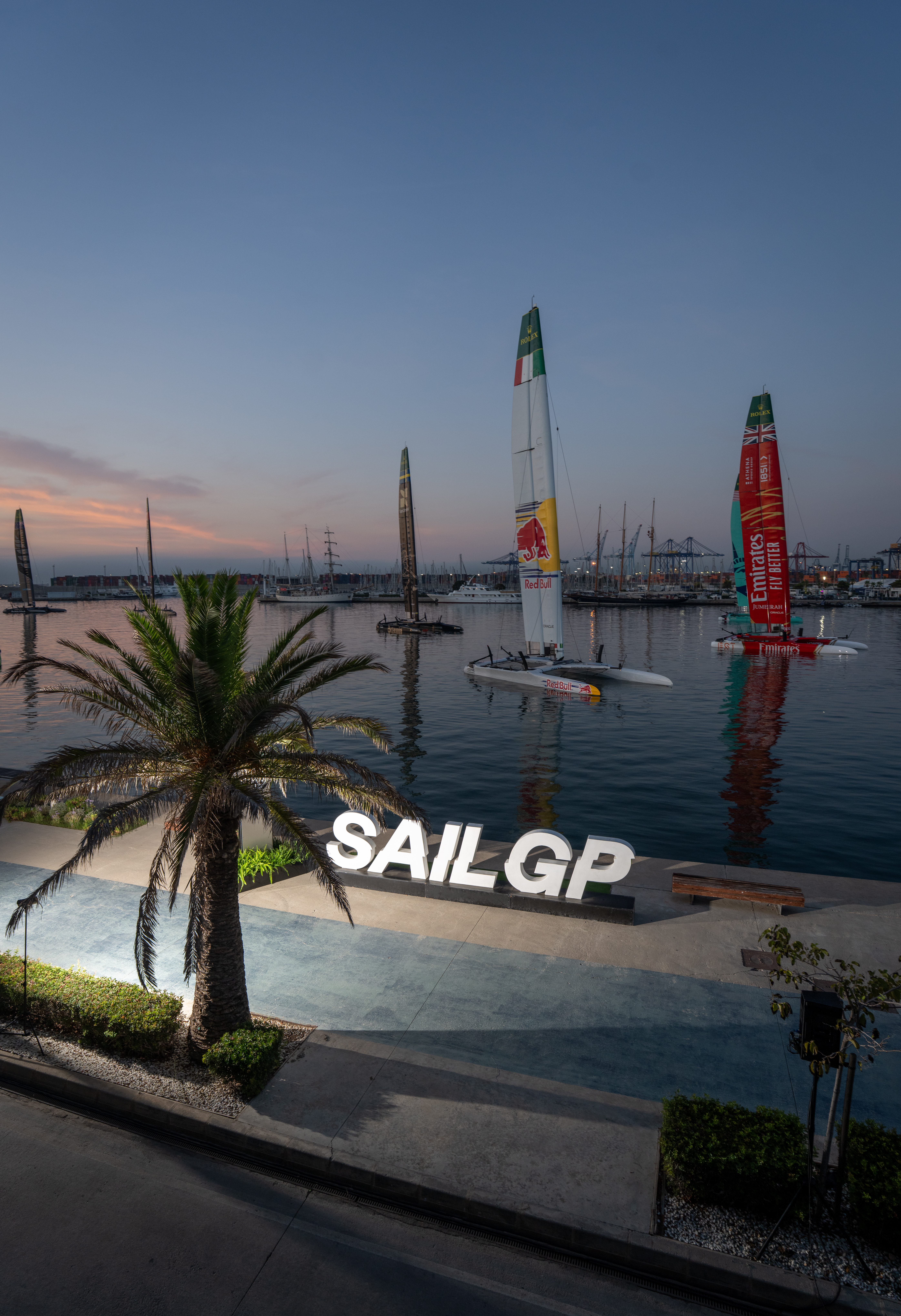 Sunrise over the F50 fleet on their moorings alongside the technical area with the SailGP branding on Race Day 1 of the Spain Sail Grand Prix in Valencia, Spain. Saturday 5 September 2026. Rolex SailGP Championship Event 10 2026 Season. Photo: Charlie Raymond Kent for SailGP. Handout image supplied by SailGP