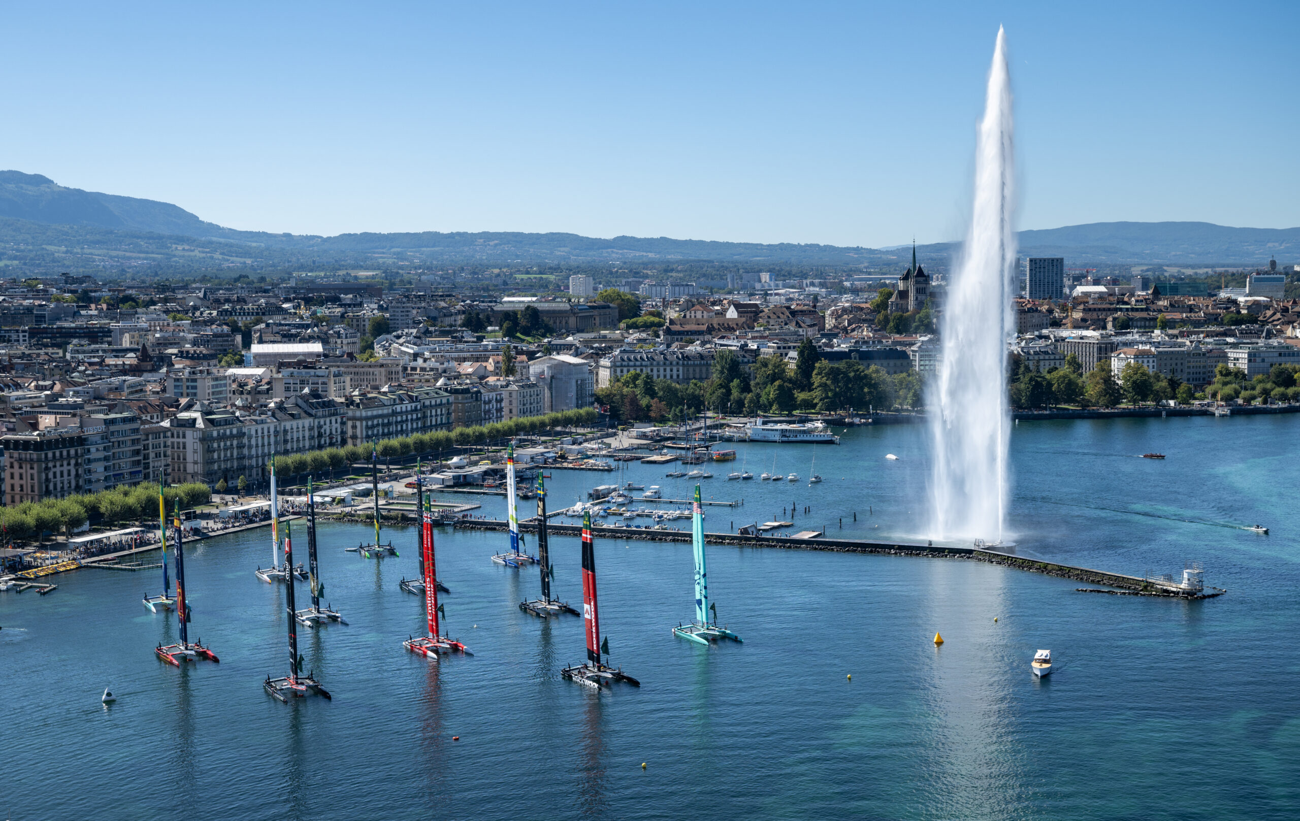 Aerial view looking towards Geneva with the SailGP fleet on their moorings outside the technical area and the Jet d'Eau on Race Day 1 of the Switzerland Sail Grand Prix in Geneva, Switzerland. Saturday 19 September 2026. Rolex SailGP Championship Event 11 2026 Season. Photo: Ricardo Pinto for SailGP. Handout image supplied by SailGP
